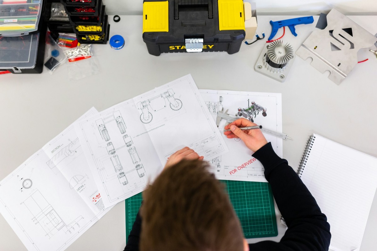 Technician reviewing technical plans beside a toolbox