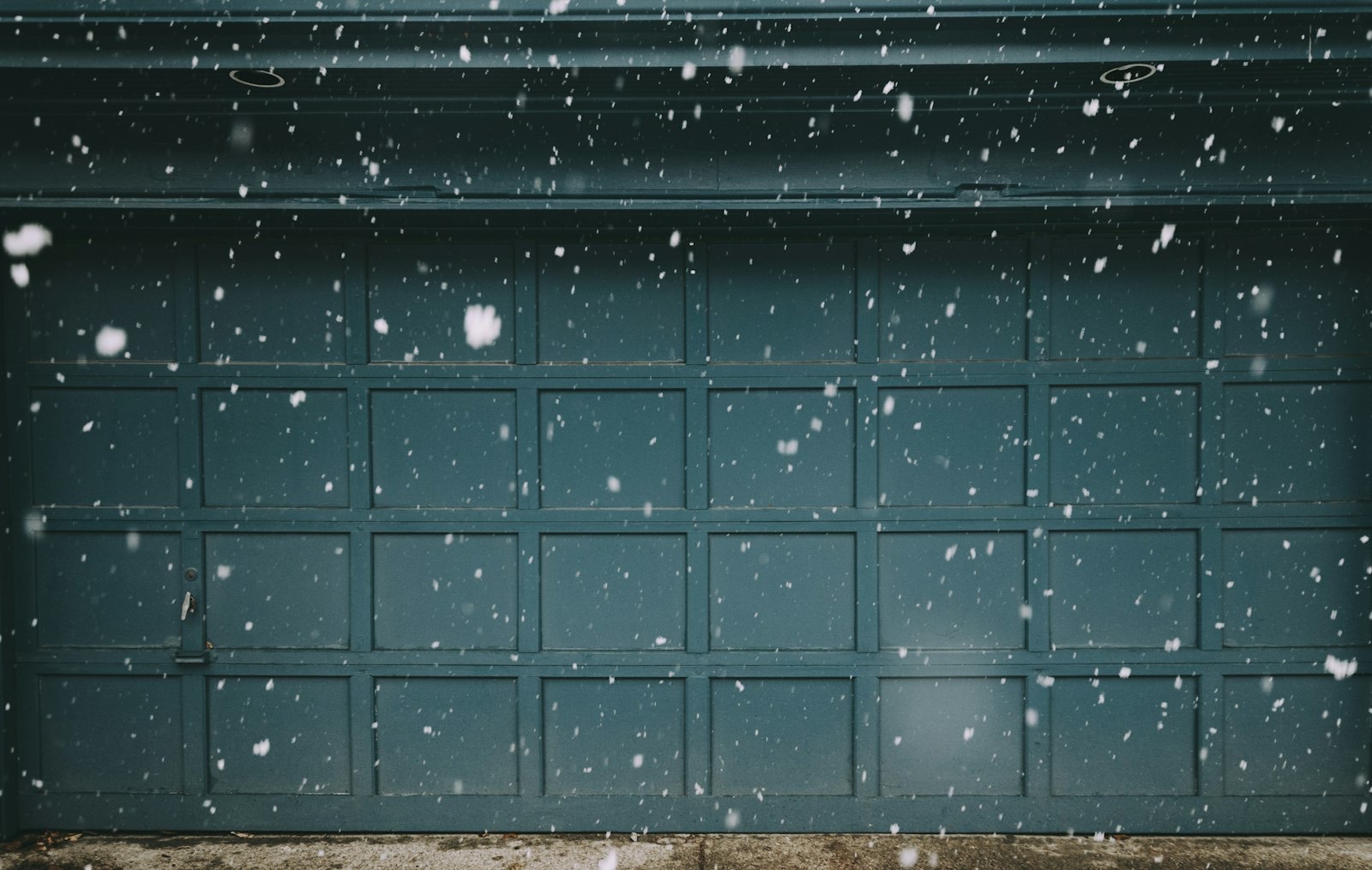 Garage door in falling snow — preventative maintenance keeps doors running through Ontario winters