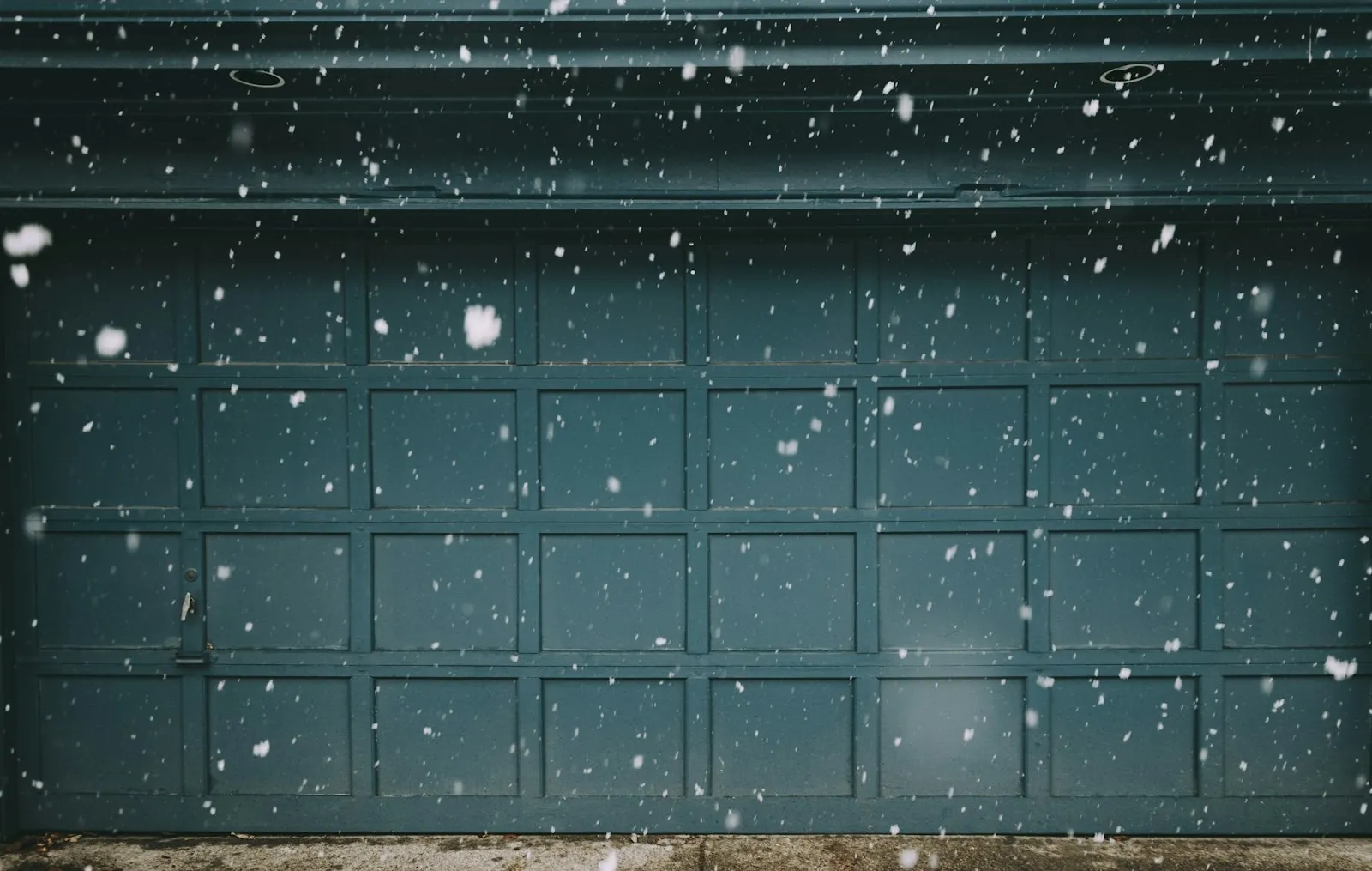 Garage door in falling snow — preventative maintenance keeps doors running through Ontario winters